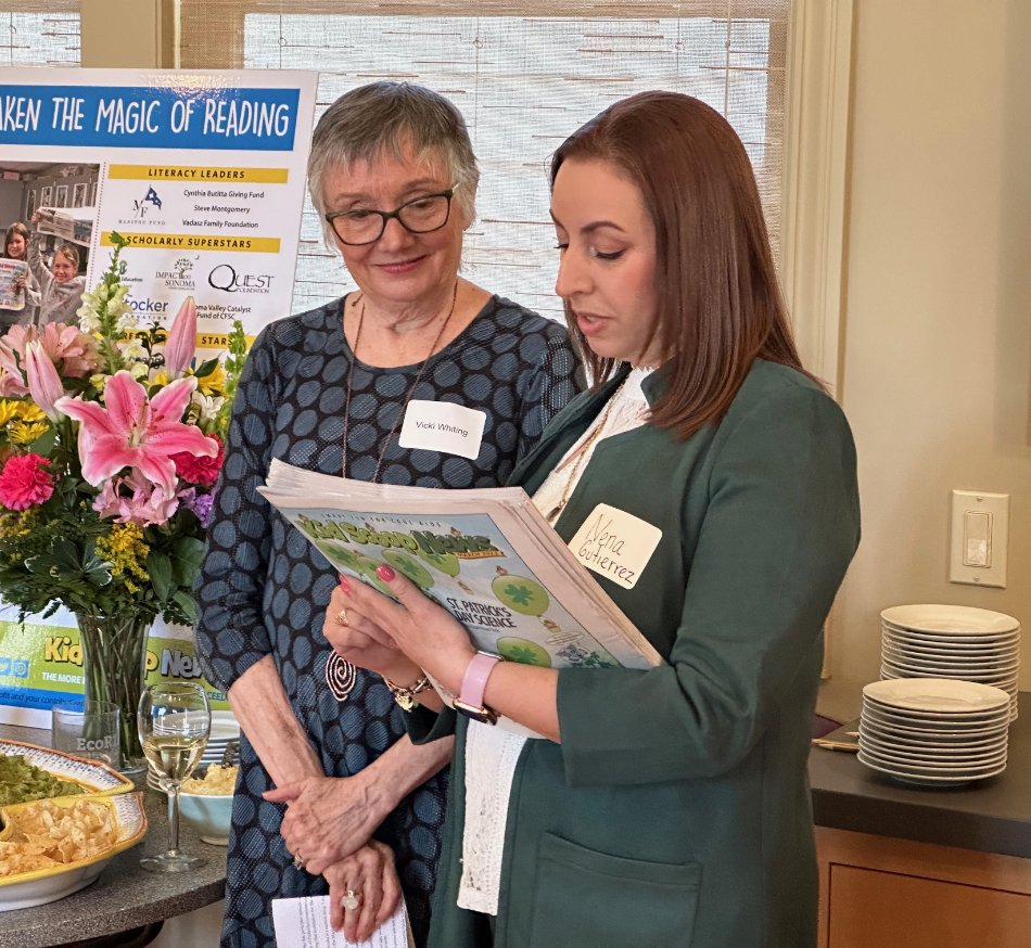 Volunteer & advocate for Kid Scoop News – image shows Vicki Whiting and Nena Gutierrez at a Kid Scoop event looking at an edition of KSN